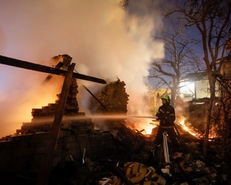 A firefighter works at the site of a home hit by a Russian drone strike in Kyiv