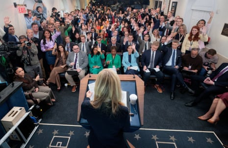 reporters raise their hands at a White House press briefing