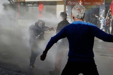 Protesters are engulfed in a water spray during an anti-government protest in Tirana