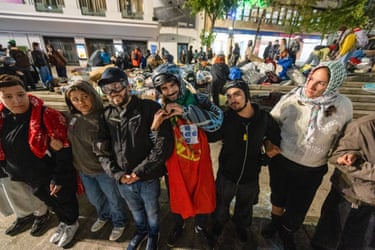 Protesters link arms in a human chain as a housing camp is cleared behind them